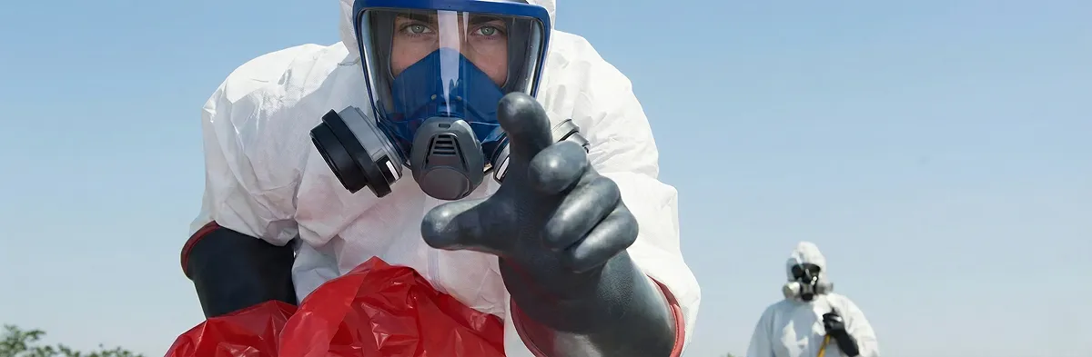 sewage clean up technician wearing protective gear handling biohazard materials in Boston, MA